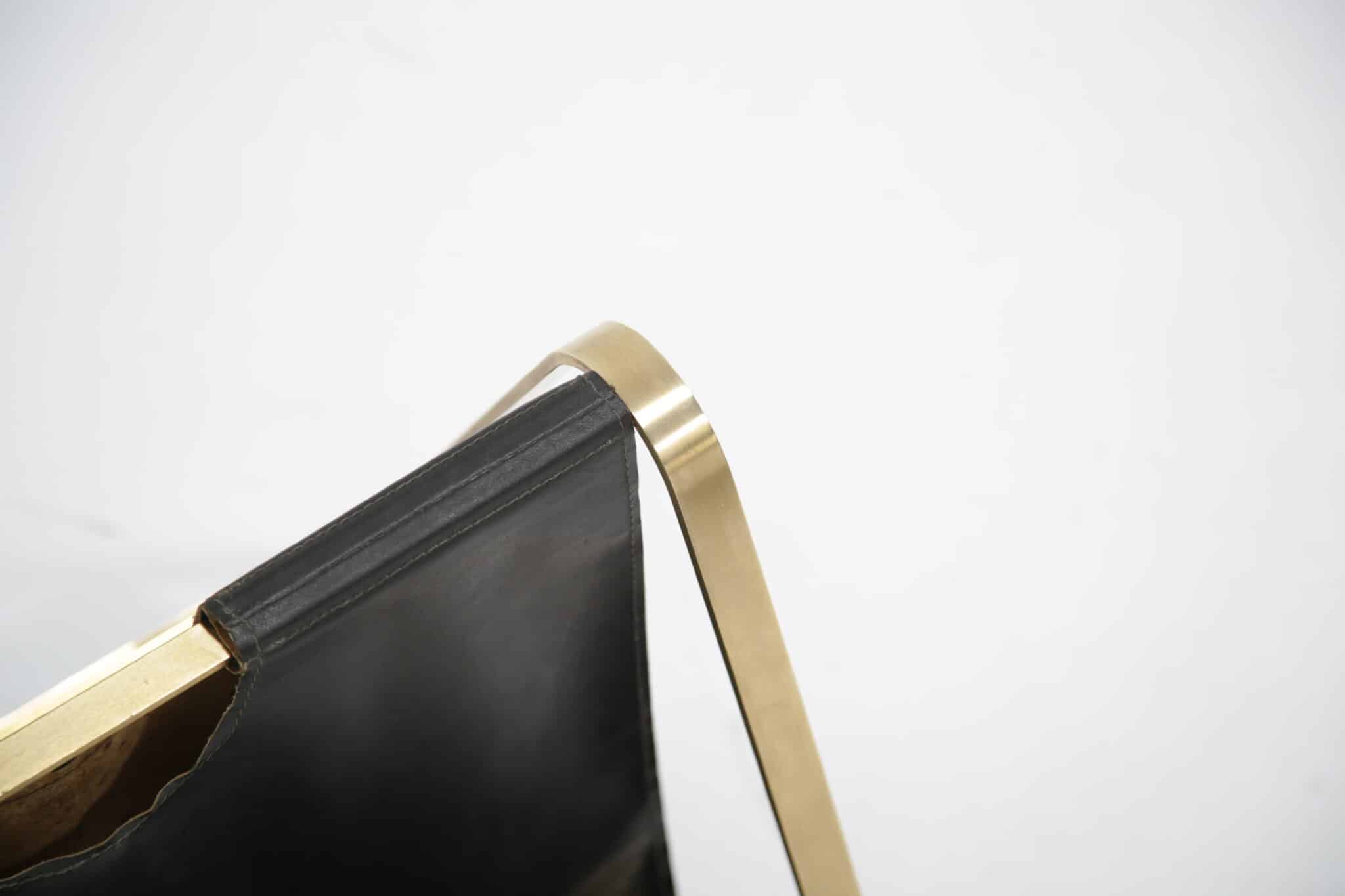 Brass and leather mid-century French magazine rack showing brass detail.