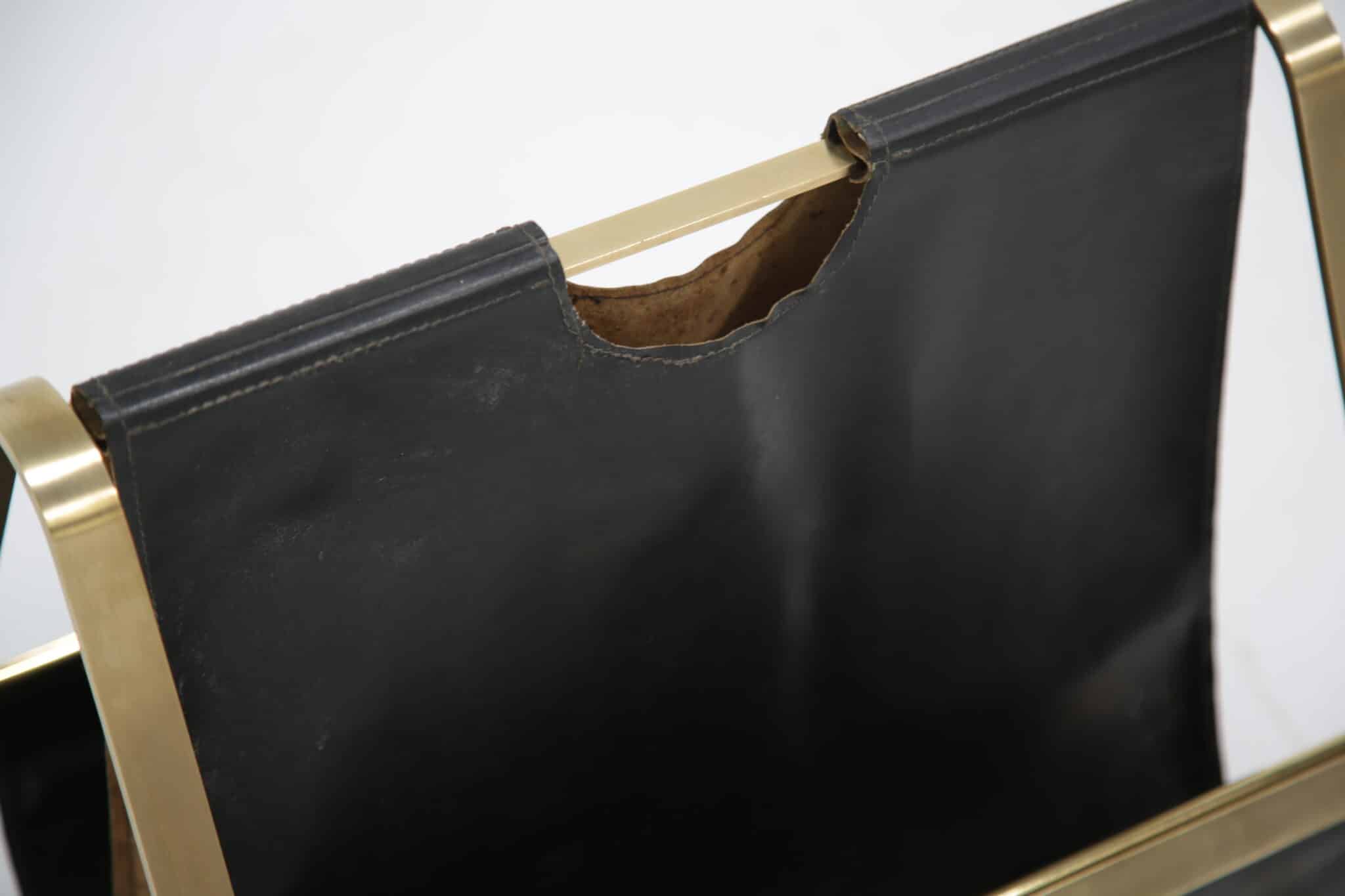 Brass and leather mid-century French magazine rack showing leather detail.